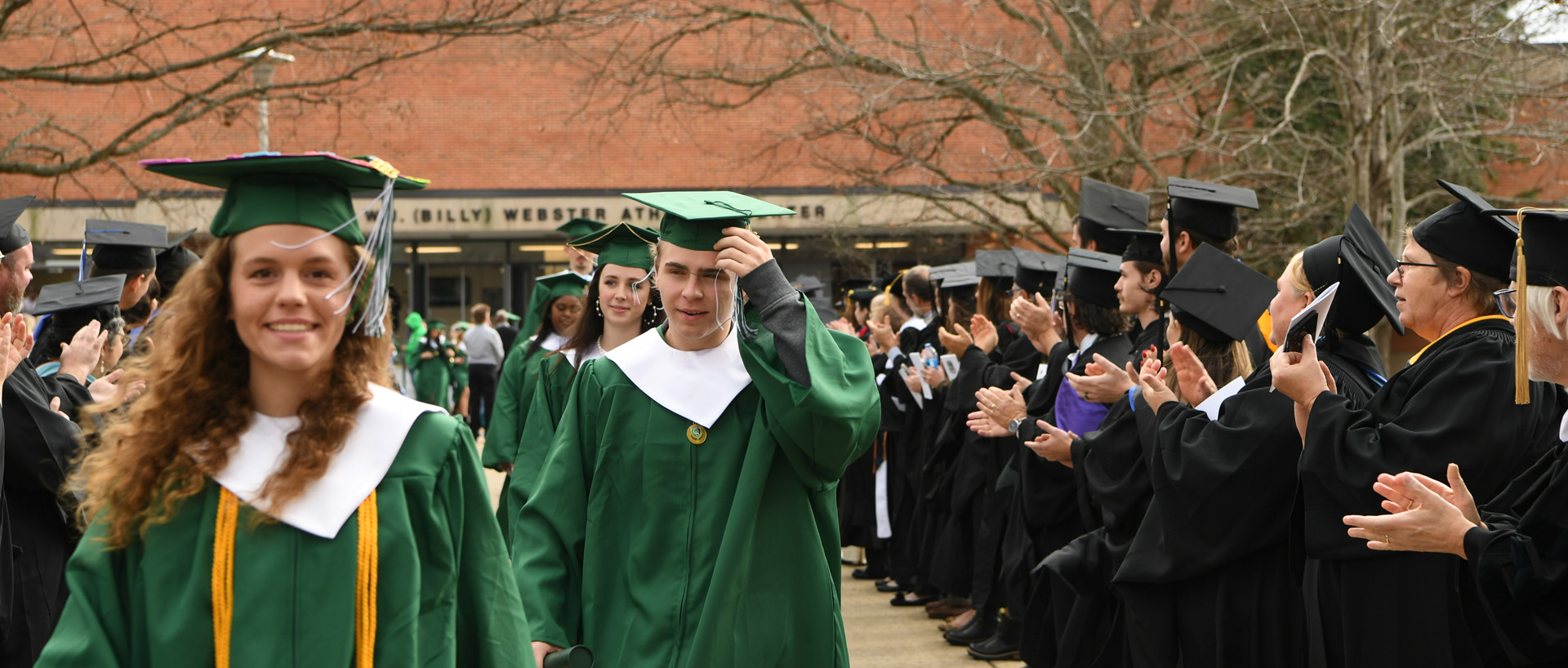 graduates walking across campus
