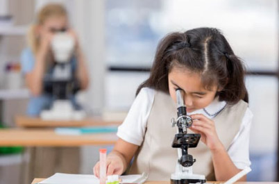 Girl looking into a microscope