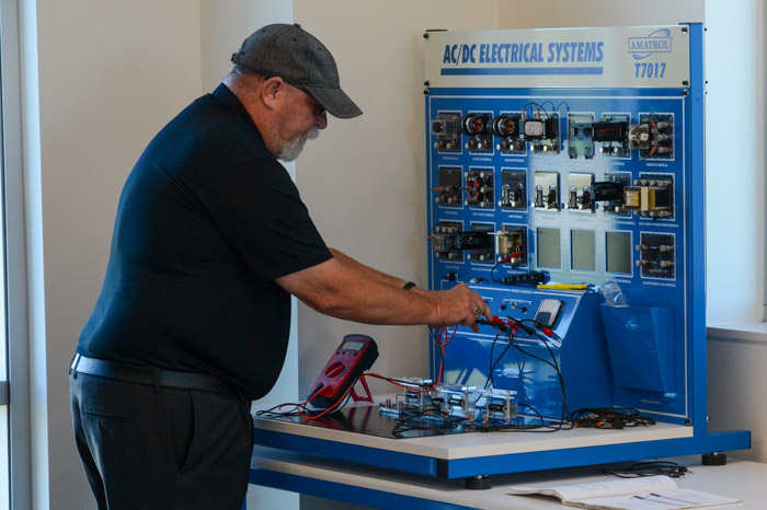 Richard Urban, Columbia State Engineering Systems Technology program director, demonstrates how to operate the new AC/DC electrical systems workstation in the new Lawrence Campus EST lab area. 