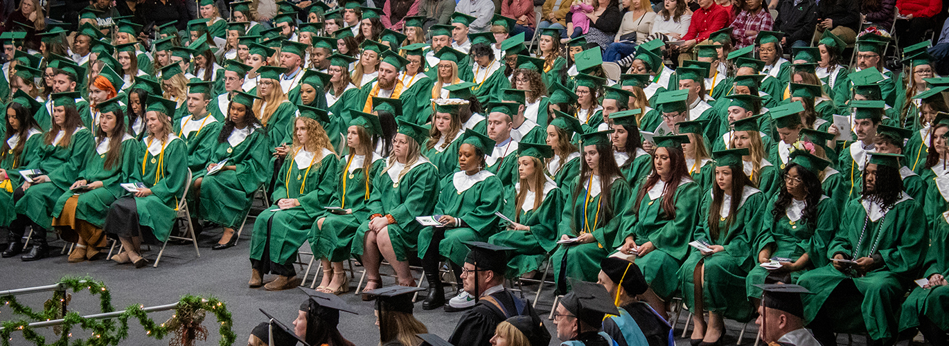 A photo shows a wide shot of the stage and graduates during the Columbia State Fall 2025 Commencement ceremony.