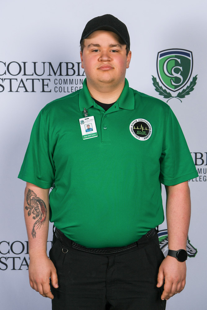 A man stands in front of a white background. 