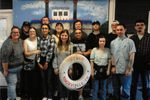 Students standing in front of riverboat painting