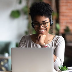 smiling woman with headphones watching course online